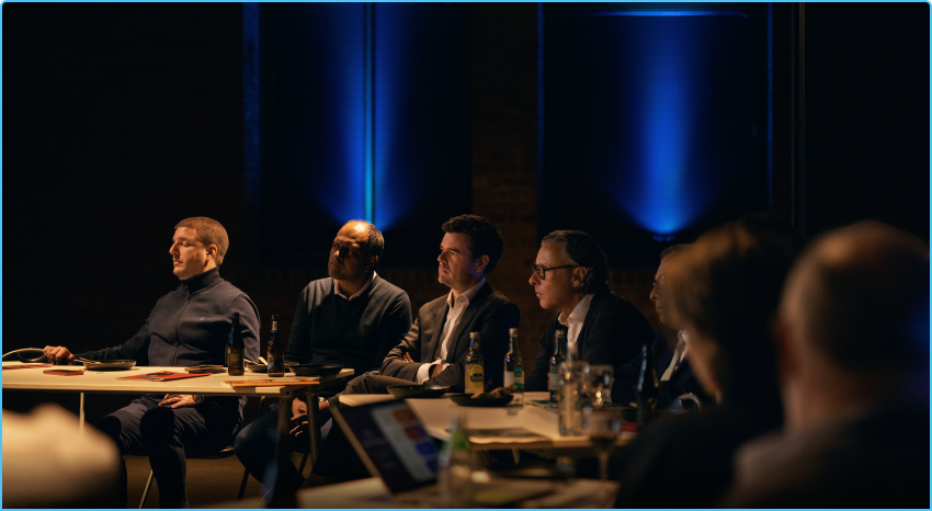 A team seated along a long table in the SPYSCAPE London debrief room
