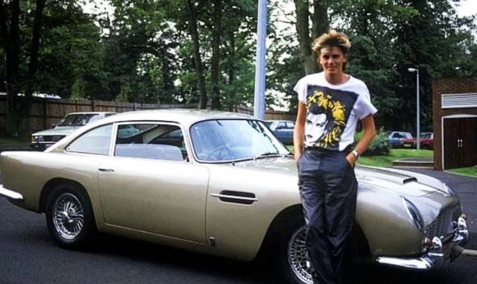Bon Jovi singer John Taylor next to his Aston Martin DB5