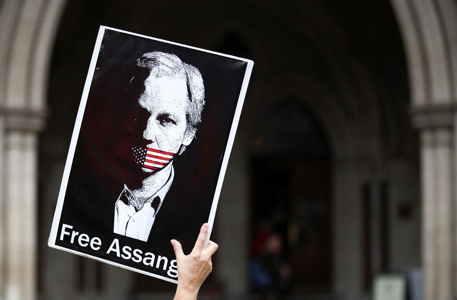 A protestor holds a sign asking British authorities to free Julian Assange