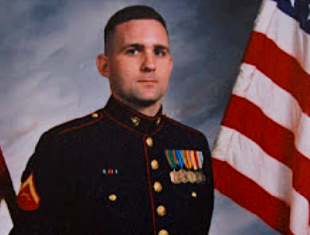 Paul Whelan in his military uniform next to the US Flag
