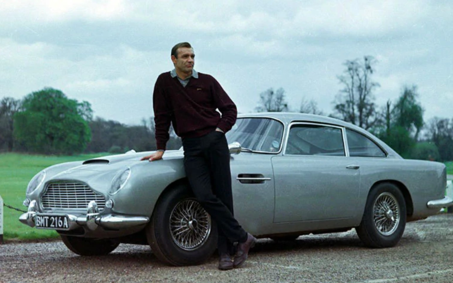 Sean Connery as 007 leans against his Aston Martin DB5