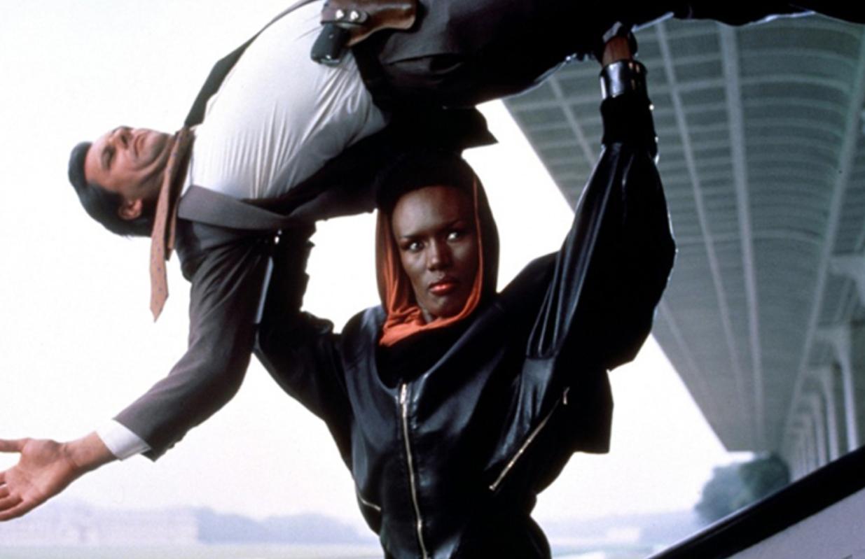 Grace Jones stars as a James Bond villain holding an enemy over her head