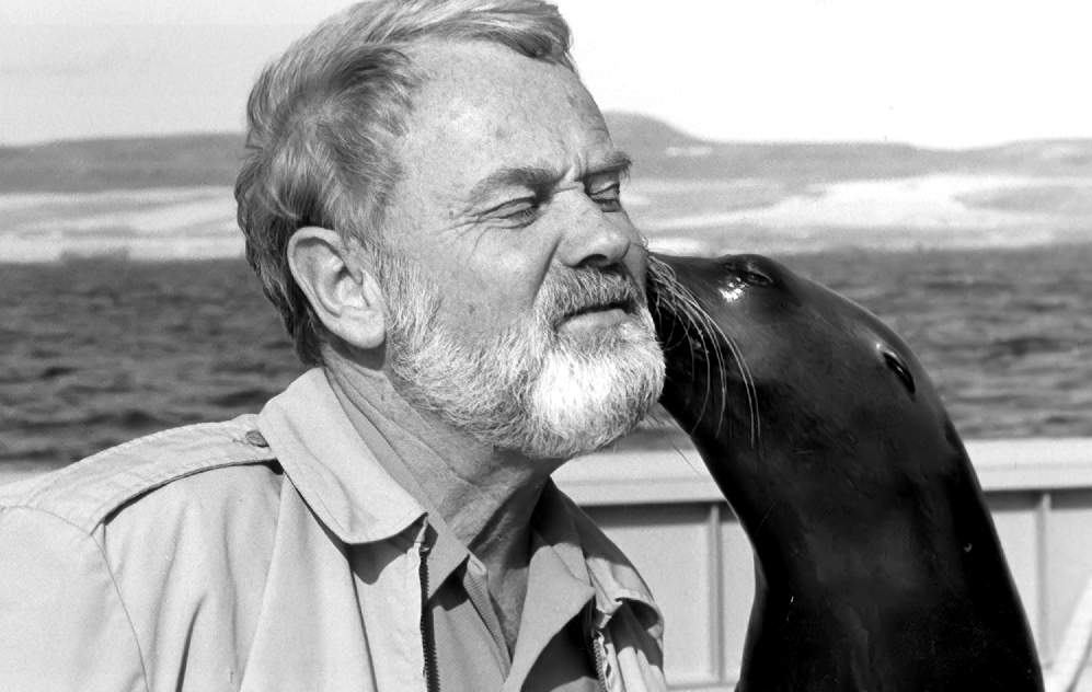 GiGi, trained for underwater recovery, nuzzles merchant mariner Capt. Arne Willehag, 1983