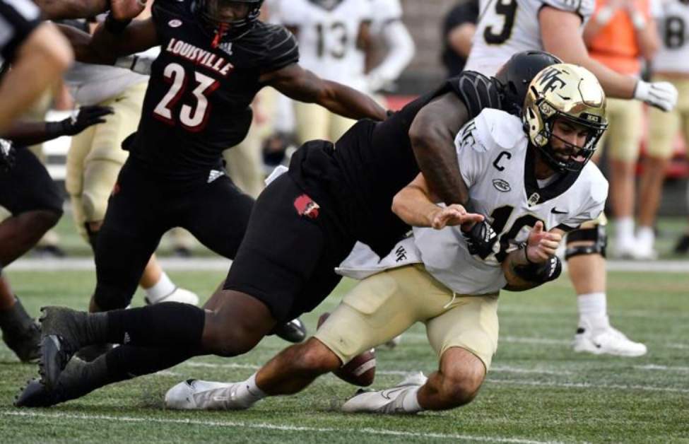Wake Forest quarterback Sam Hartman is sacked by Louisville’s Caleb Banks in 2022