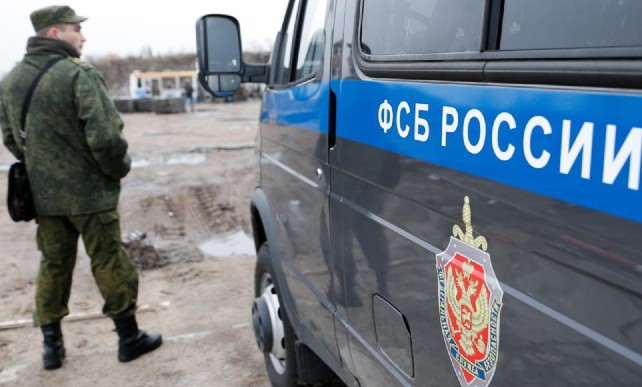 Russia's FSB spy agency, an officer stands by a van